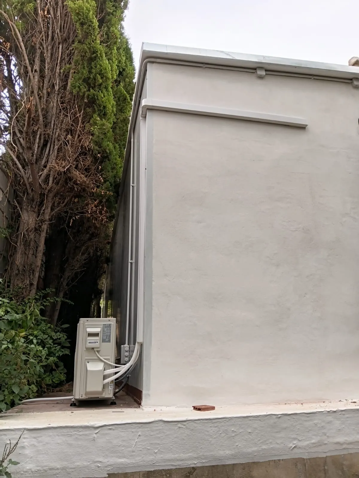 Unidad exterior junto a la fachada de una vivienda
