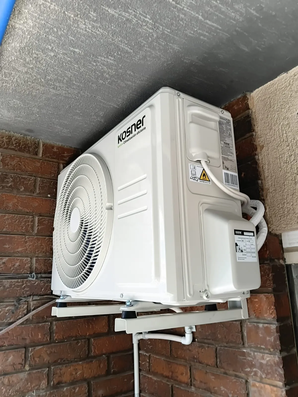 Unidad exterior Kosner de climatización instalada en una pared