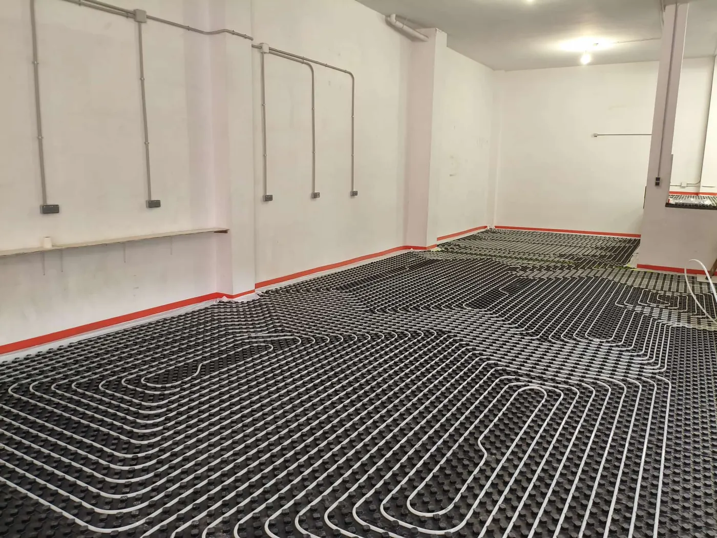 Circuitos de tubería de suelo radiante instalados en un local