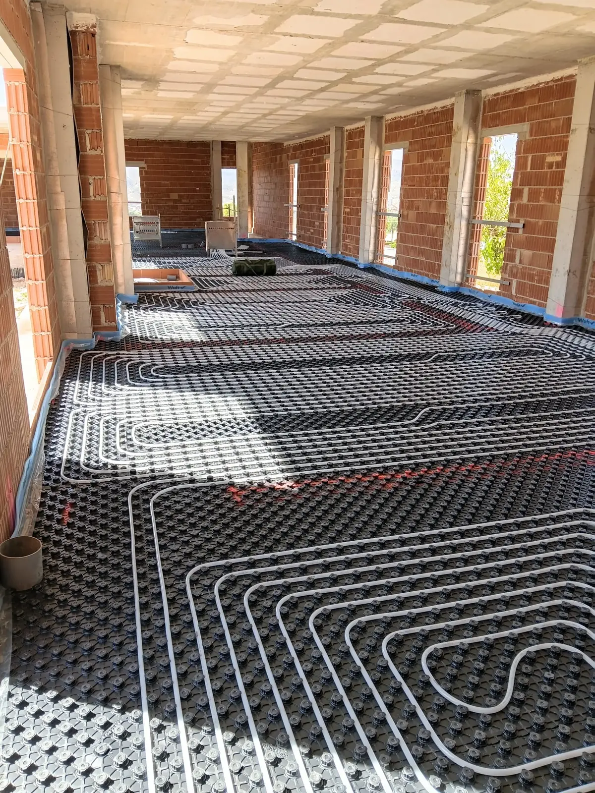 Suelo radiante instalado en la planta completa de un edificio en obra